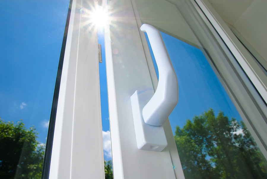 A vinyl window is slightly opened, showing the sun peeking through the glass.